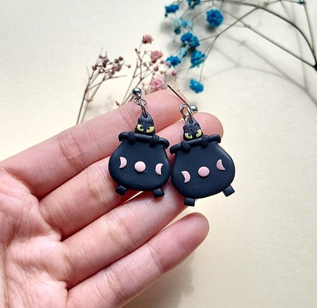 Halloween cat earrings in cauldron.